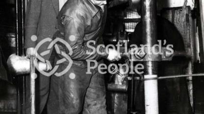 Men removing drilled core on boring tower in the Forth, 1955