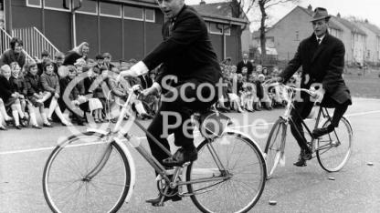 Actors Peter Byrne and Geoffrey Adams riding bicycles, 1967