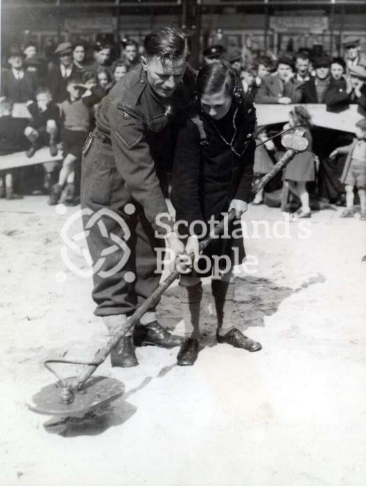 Soldier and boy with mine detector, 1944