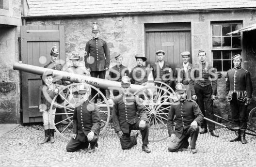 Volunteer firemen and estate workers with a pump mounted on wheels, c 1905