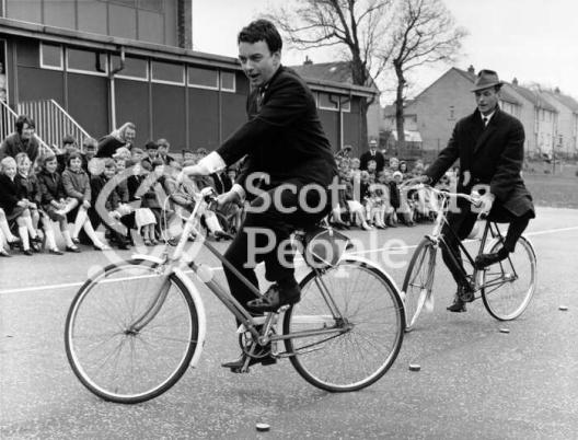 Actors Peter Byrne and Geoffrey Adams riding bicycles, 1967