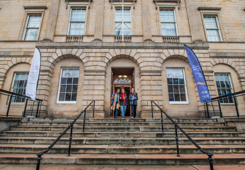 The outside of General Register House in Edinburgh with three women at the top of the stairs leaving the building